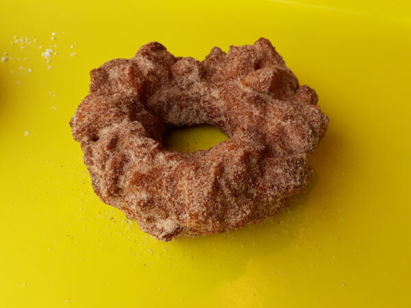A crispy donut made from small dough pieces joined together, coated in autumn spice sugar.