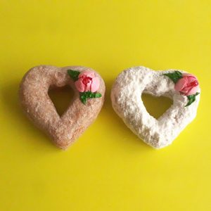A beautifully crafted Valentine’s Powdered Sugar Croissant Cupid Donut, dusted with fine powdered sugar, topped with a delicate candy rose, and pierced with a strawberry cream Pocky stick as Cupid’s arrow. A crispy, flaky croissant donut perfect for Valentine’s Day.