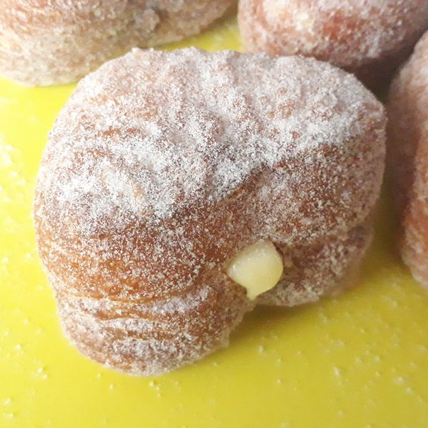 A delicious set of Mini Croissant Heart Donuts filled with Nutella, custard cream, and raspberry jelly, lightly coated with regular sugar and powdered sugar, arranged on a display tray. A perfect bite-sized indulgence for Valentine’s Day and special occasions.