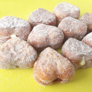 A delicious set of Mini Croissant Heart Donuts filled with Nutella, custard cream, and raspberry jelly, lightly coated with regular sugar and powdered sugar, arranged on a display tray. A perfect bite-sized indulgence for Valentine’s Day and special occasions.