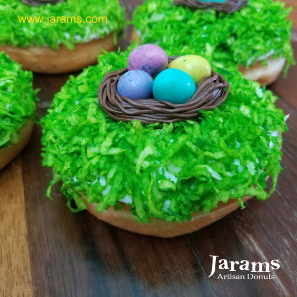 Easter donut with chocolate icing, blue coconut grass, and chocolate egg nest on top