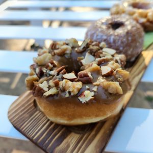 Close-up of Jarams Maple Icing Mixed Nut Donut, richly topped with pecans and almonds.