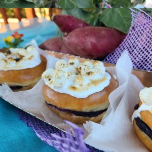Close-up of Jarams Purple Yam Jam S'Mores Donut, sliced to show the purple yam jam and torched marshmallow topping.