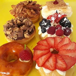 A box of twelve vibrant gourmet specialty mix donuts by Jarams Donuts.